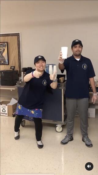 Students holding up cups of coffee